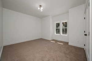 Carpeted empty room featuring baseboards