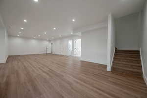 Unfurnished living room featuring recessed lighting, stairway, and light wood finished floors