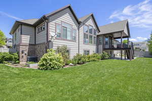View of home's exterior with stairway, roof with shingles, brick siding, a patio, and a deck