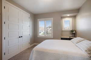 Bedroom with light carpet and a closet