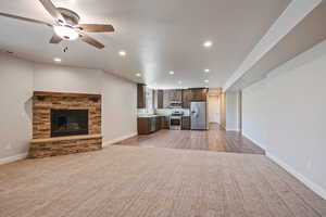 Unfurnished living room featuring recessed lighting, a stone fireplace, and a ceiling fan
