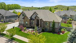Craftsman inspired home featuring a mountain view, concrete driveway, stone siding, and a residential view