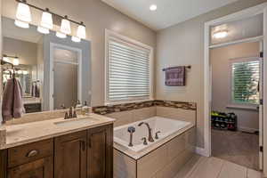 Full bathroom with light tile patterned floors, vanity, a garden tub, a stall shower, and recessed lighting