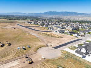 Aerial view of property and surrounding area with a mountainous background and nearby suburban area