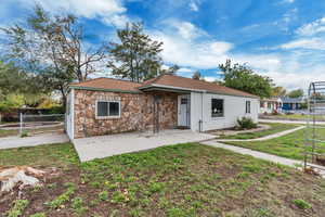 View of front of home featuring stone siding and roof with shingles