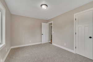 Unfurnished bedroom featuring carpet flooring and a textured ceiling