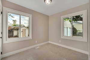 Carpeted empty room featuring baseboards