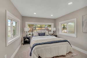 Carpeted bedroom with baseboards and recessed lighting