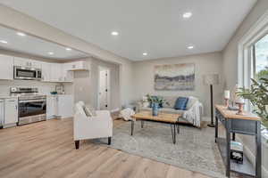 Living room with recessed lighting and light wood-type flooring