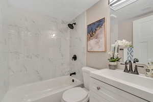 Bathroom featuring shower / tub combination, vanity, and a textured ceiling