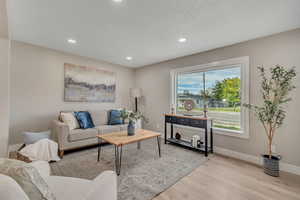 Living area featuring light wood-style floors and recessed lighting