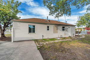 Back of house featuring a patio area and roof with shingles