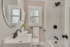 Bathroom featuring vanity, washtub / shower combination, and healthy amount of natural light