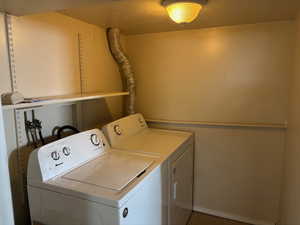 Washroom featuring washer and dryer and a textured ceiling