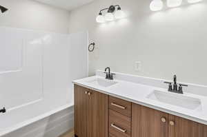 Full bathroom with double vanity and bathtub / shower combination