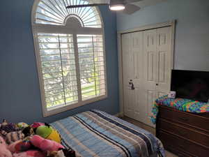 Bedroom with carpet floors, a closet, and a ceiling fan