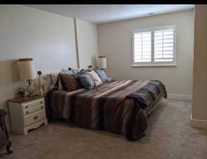 Bedroom with light colored carpet and baseboards