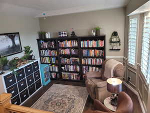 Living area with lofted ceiling and dark wood-style floors