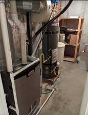 Utility room featuring heating unit and water heater