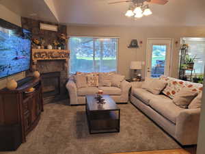 Living room featuring a stone fireplace and carpet floors