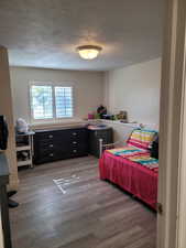 Bedroom featuring a textured ceiling and light wood-style floors