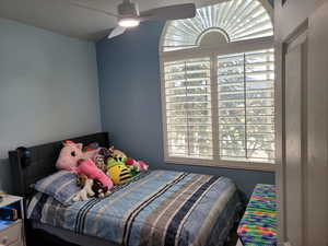 Bedroom featuring ceiling fan and lofted ceiling