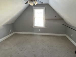 Additional living space featuring a ceiling fan, a textured ceiling, vaulted ceiling, and carpet floors