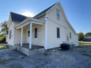 View of front of house featuring covered porch and a shingled roof