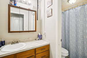 Bathroom with vanity, curtained shower, and a textured ceiling