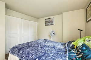 Bedroom featuring a textured ceiling and a closet