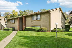 View of front of property with a front lawn and stucco siding