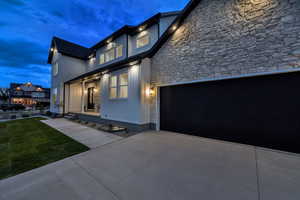 View of front of home with stone siding, driveway, and a front yard