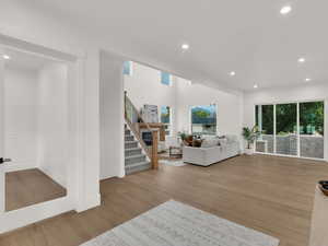 Living room with recessed lighting, stairway, and light wood-style flooring