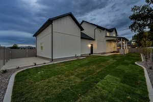 Back of house with a fenced backyard, a patio area, and board and batten siding