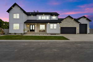 Modern farmhouse style home featuring a porch, board and batten siding, driveway, a front lawn, and an attached garage