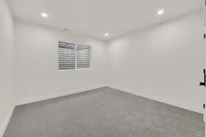 Empty room featuring carpet flooring and recessed lighting