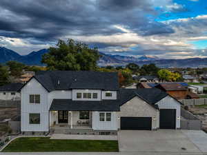 Modern inspired farmhouse with covered porch, a mountain view, and a shingled roof