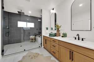 Bathroom featuring double vanity, a stall shower, recessed lighting, and light tile patterned floors