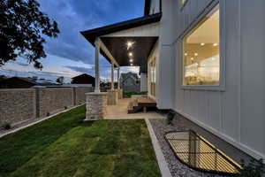 Yard at dusk with a fenced backyard and a patio area