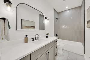 Full bathroom featuring vanity, shower / bath combination, recessed lighting, and light marble finish flooring