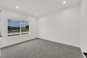 Carpeted empty room with recessed lighting and a mountain view