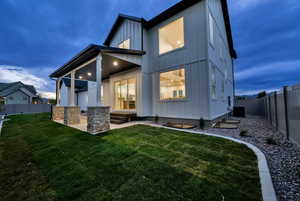 Back of house with board and batten siding, a fenced backyard, and a patio area