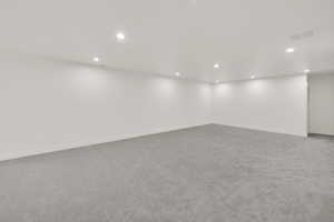 Basement with light colored carpet and recessed lighting