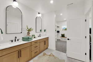 Full bath featuring double vanity, recessed lighting, light tile patterned floors, and light carpet