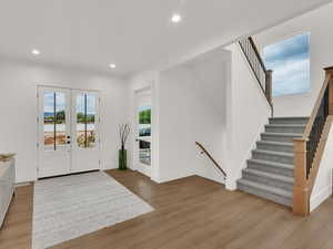 Entryway featuring french doors, recessed lighting, light wood-style floors, and stairway