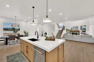 Kitchen with decorative light fixtures, light wood-type flooring, recessed lighting, light brown cabinetry, and open floor plan
