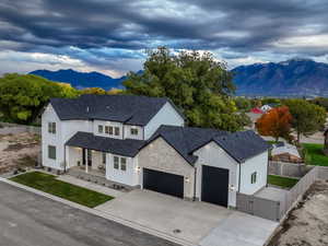 Modern farmhouse with a mountain view, a porch, board and batten siding, and stone siding