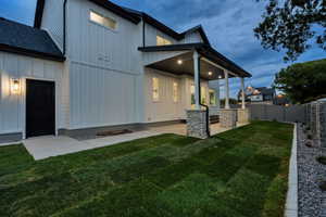 Rear view of house featuring board and batten siding and a fenced backyard