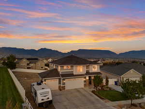 View of front of property featuring driveway, a mountain view, and a residential view
