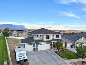 View of front of home featuring concrete driveway, a mountain view, a residential view, and stone siding